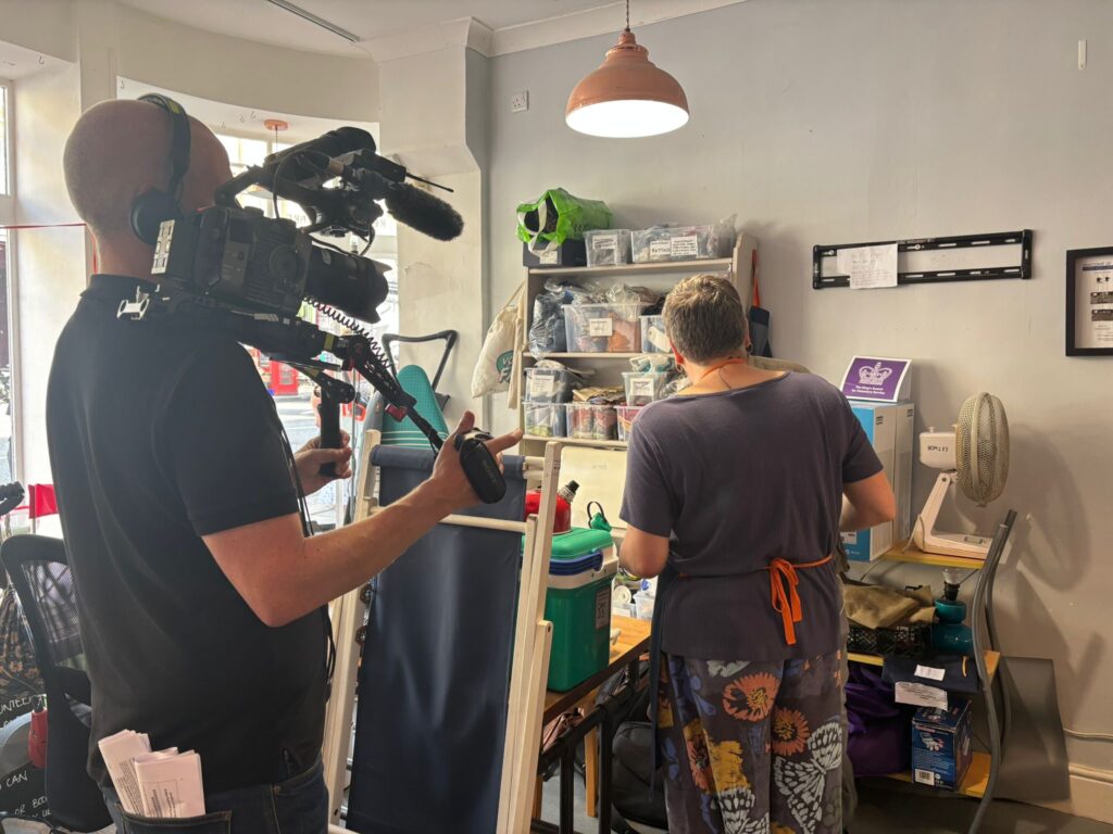 A cameraman filming the CEO Ruth inside the Share and Repair shop.