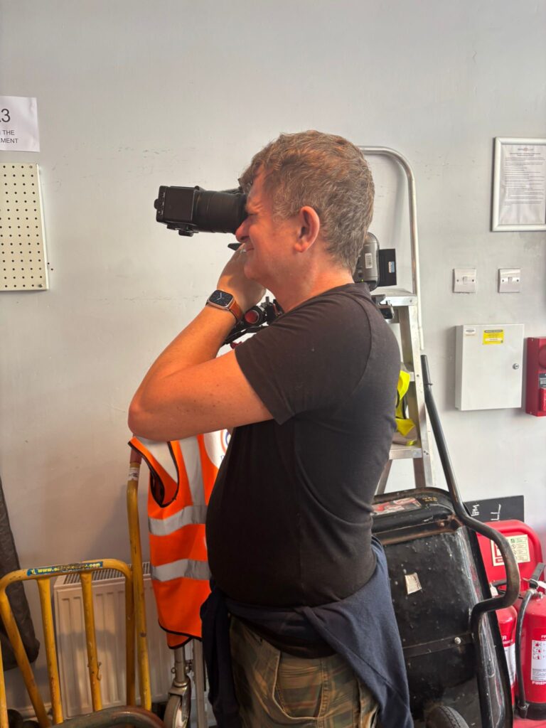 A cameraman taking a photo inside the Share and Repair shop